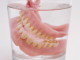 False teeth in glass of water, close-up